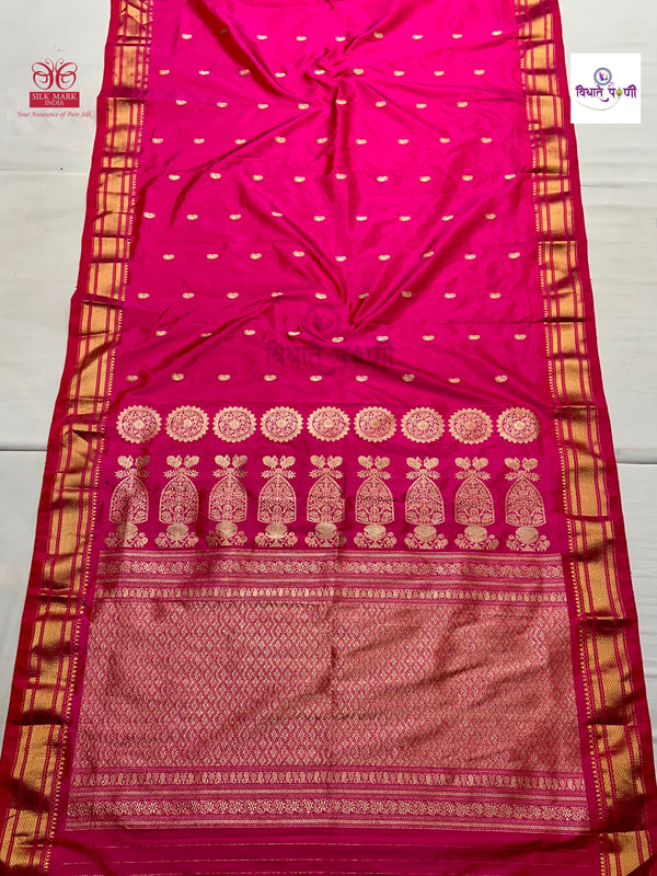 A bright pink paithani silk saree with gold zari embroidery, featuring a wide border with traditional motifs and a patterned body with small gold dots.