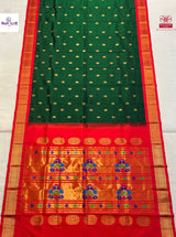 A green and red silk saree with gold zari detailing, featuring a green body with small gold dots, a red border, and a wide golden pallu with intricate floral motifs.