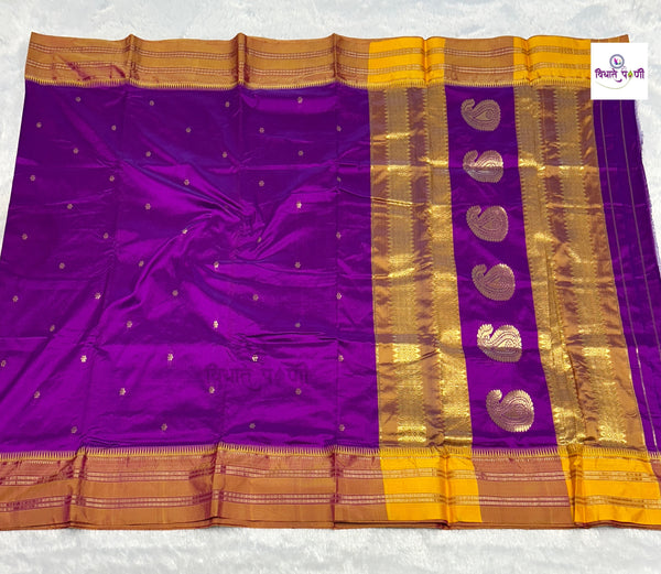 A purple silk saree with a wide gold zari border, featuring metallic gold paisley motifs on the pallu and small gold dots across the body, laid flat on a white background.