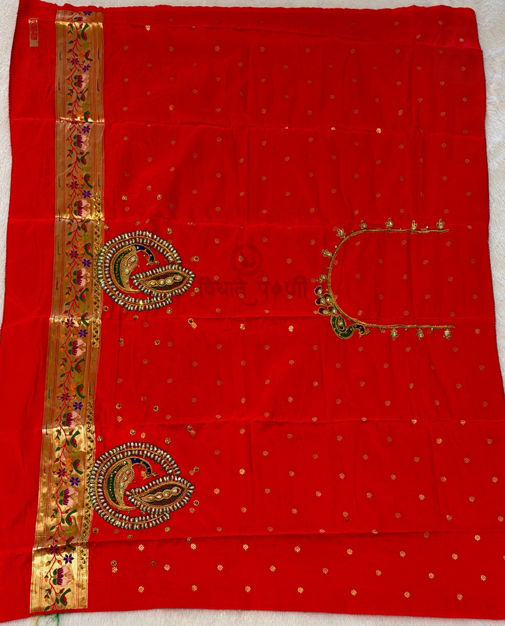 Matching designer red Aari work blouse piece with gold embroidered neckline and Paithani border